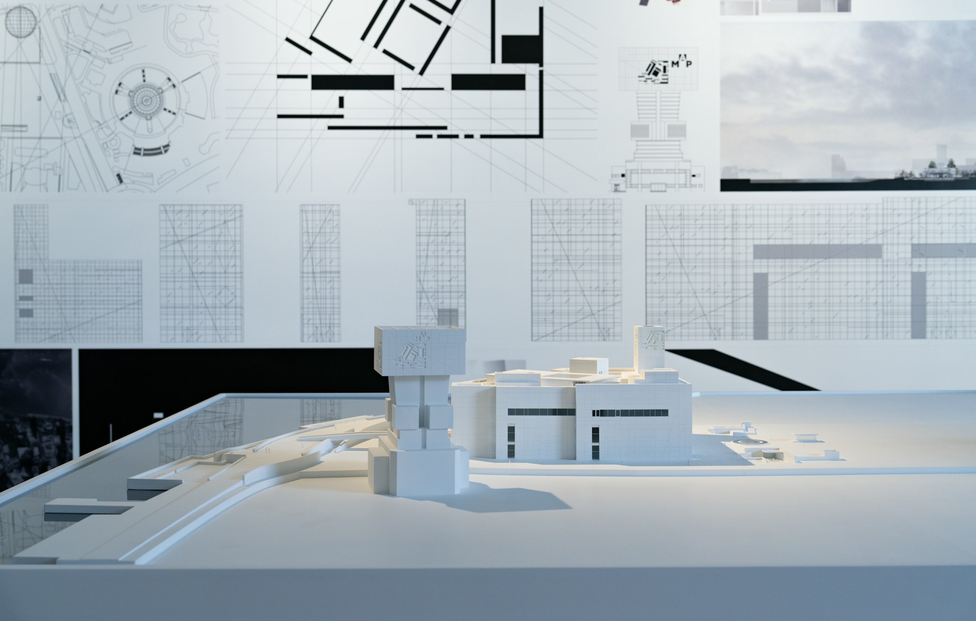 Architectural model with blueprints on wall